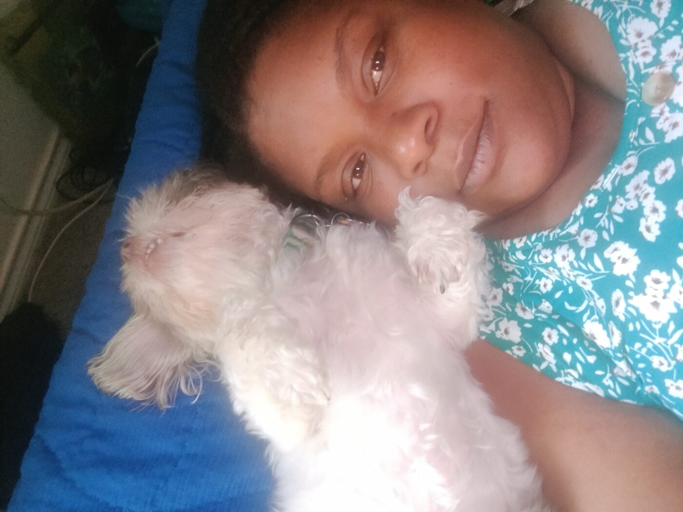 Tabitha cuddling a small white dog